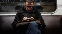 A man reads using his smartphone on the subway