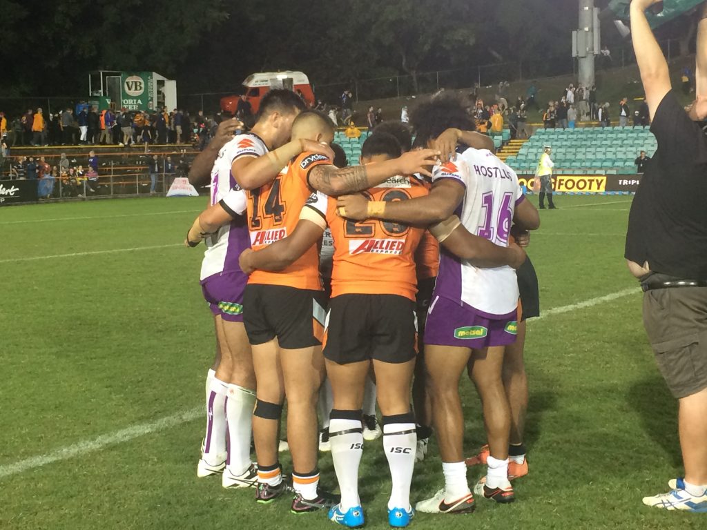 NRL players praying after a match