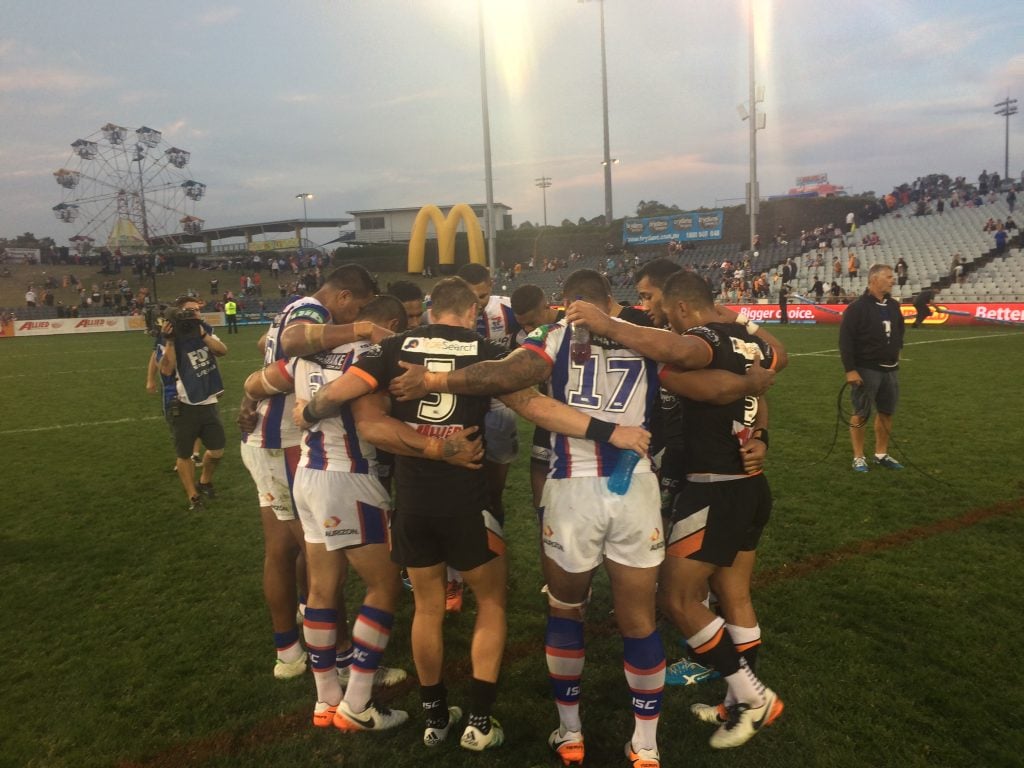 NRL players praying after a match