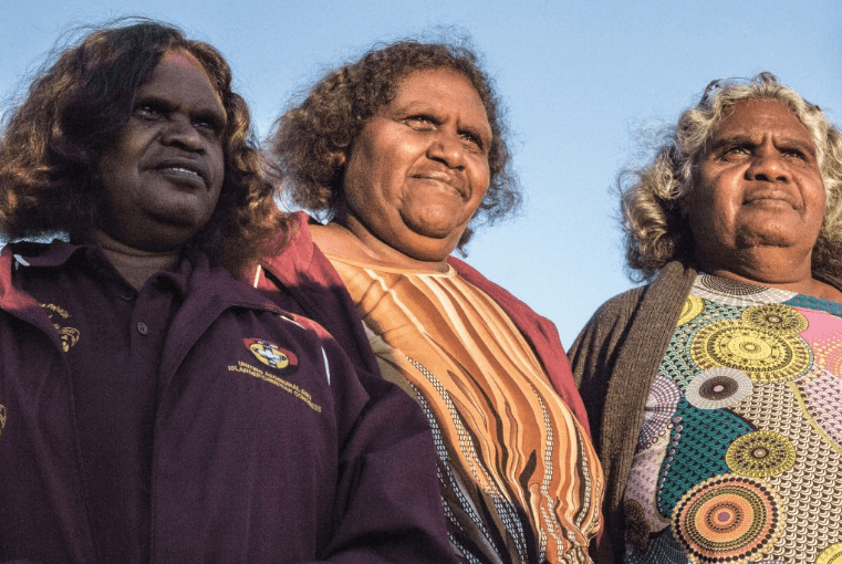 Katrina (centre) watches the sunrise over Pukatja in Central Australia with two other Pitjantjatjara translators before a day of worship and thanksgiving on Easter Sunday.