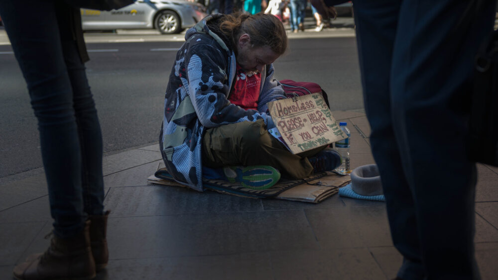 A homeless person begs on the streets of Sydney