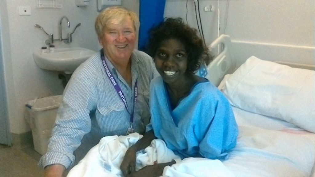 Hospital chaplain Jeff Godwell cheers up an Aboriginal patient at Townsville Hospital.