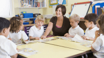 Students read with a teacher in class