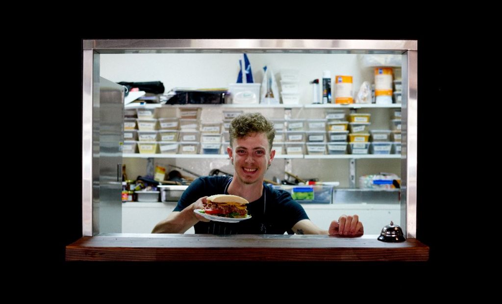 Finn, Hope Street Café staff, serves up a meal with a smile