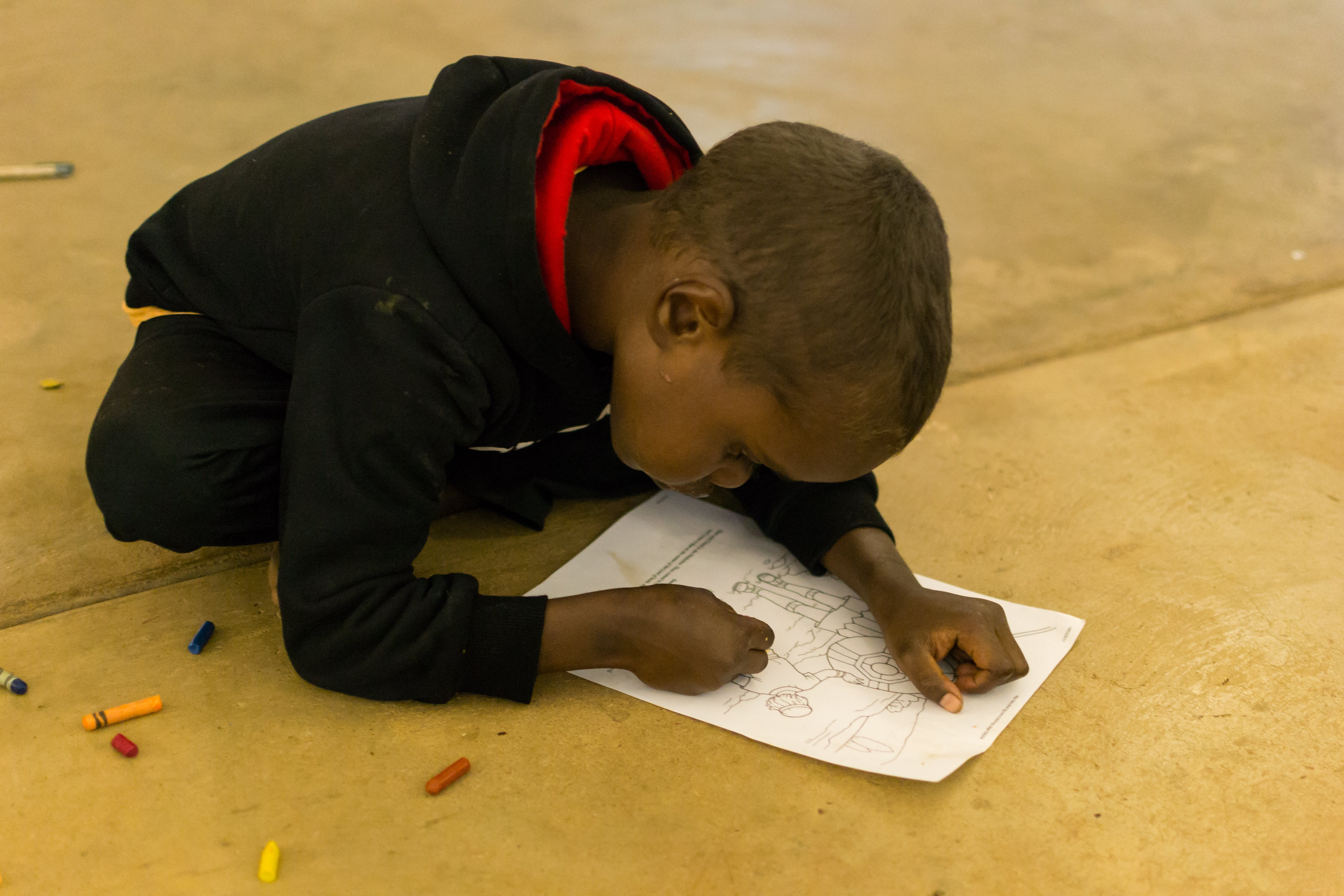 A child colours in at Kids Club, Barunga
