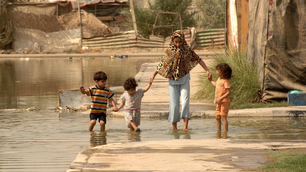 Iraqi family wades through water