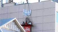 Jarrod McKenna and Delroy Bergsma are suspended four storeys up, protesting what is happening on Manus Island
