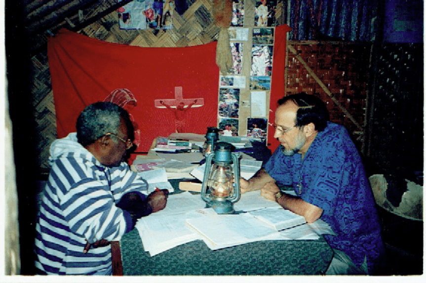 Joseph Mala and John Harris translating by the light of a hurricane lantern