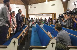 Attorney Lee Merritt, left, with Botham Jean’s mother, Allison Jean, to his right, speaks to the news media at the Dallas West Church of Christ after a prayer vigil on Sept. 8, 2018. RNS photo by Bobby Ross Jr.