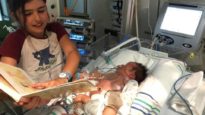 Eleanor Scoullar reads to her precious baby brother, Ethan.