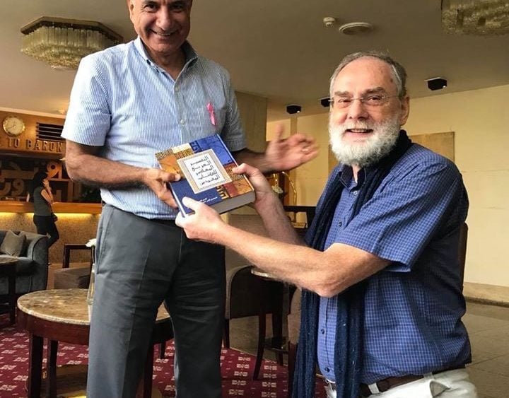 Riad Kassis, left, receives a copy of the Arabic Contemporary Bible Commentary in Cairo last October.