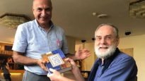 Riad Kassis, left, receives a copy of the Arabic Contemporary Bible Commentary in Cairo last October.
