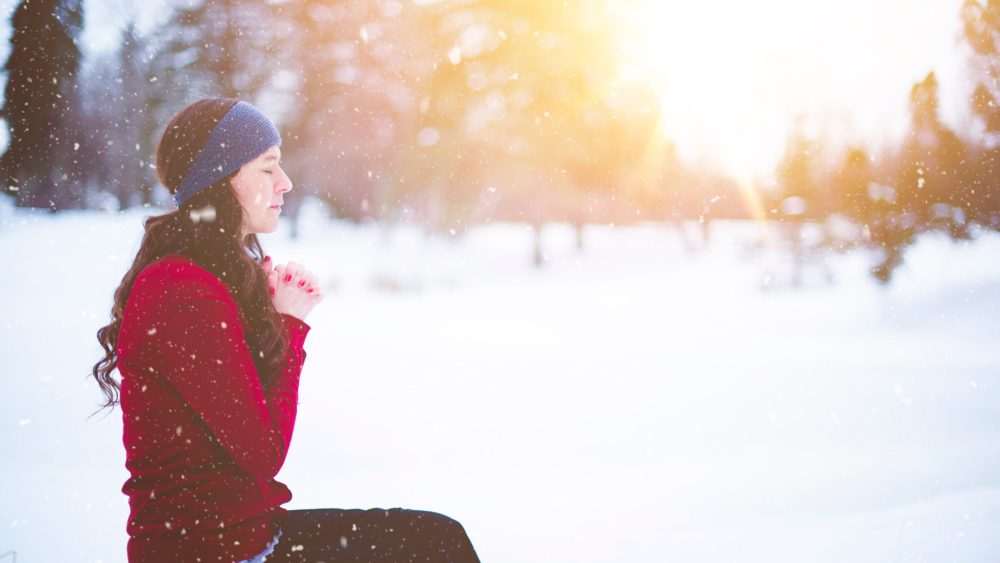 Woman praying in snow