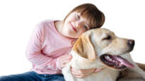 Child with down syndrome cuddling with dog