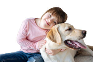 Child with down syndrome cuddling with dog