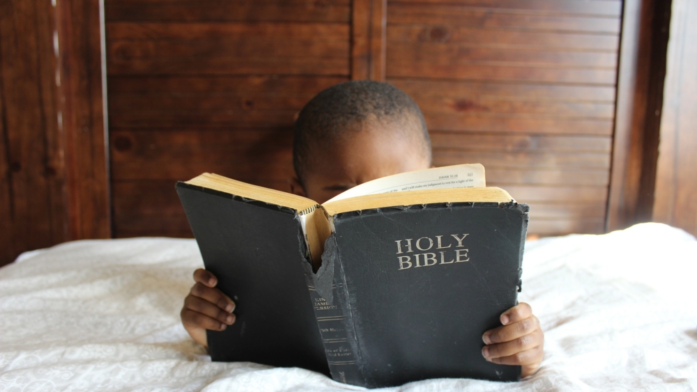 child reading Bible