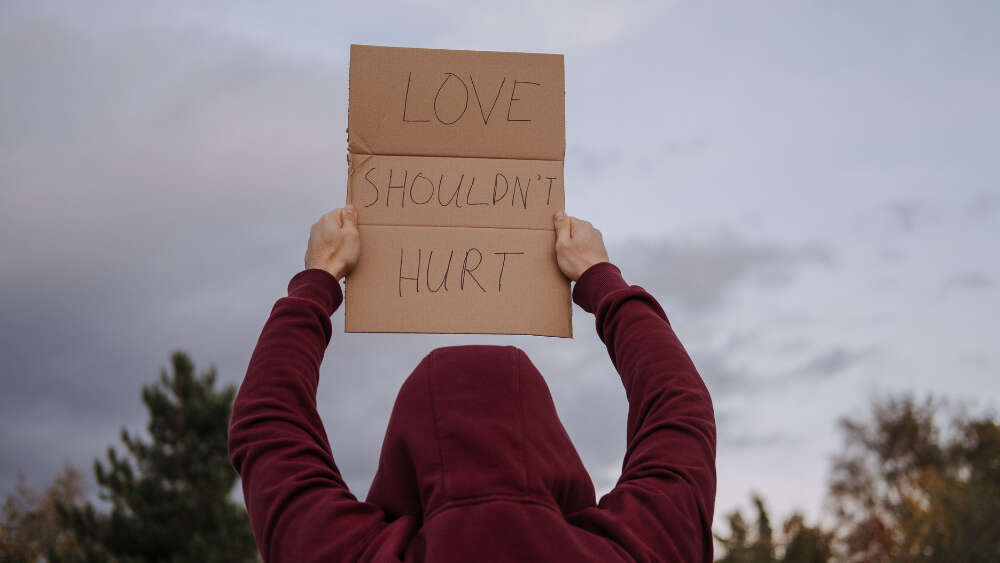 Young person holding love sign