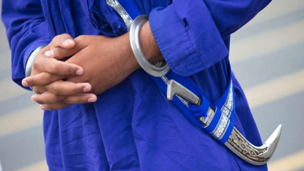 A Sikh wearing a kirpan (around his waist)