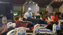 A healthcare worker in personal protective equipment (PPE) attends to a Covid19 patient in the isolation ward. A banquet hall temporarily converted to a Covid19 ward for coronavirus patients. Image: Naveen Sharma / WorldVision Australia