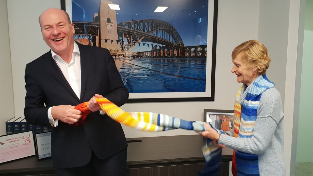 Trent Zimmerman, (Liberal) Member for North Sydney, NSW is presented with a climate stripe scarf by knitter Helen Bathgate
