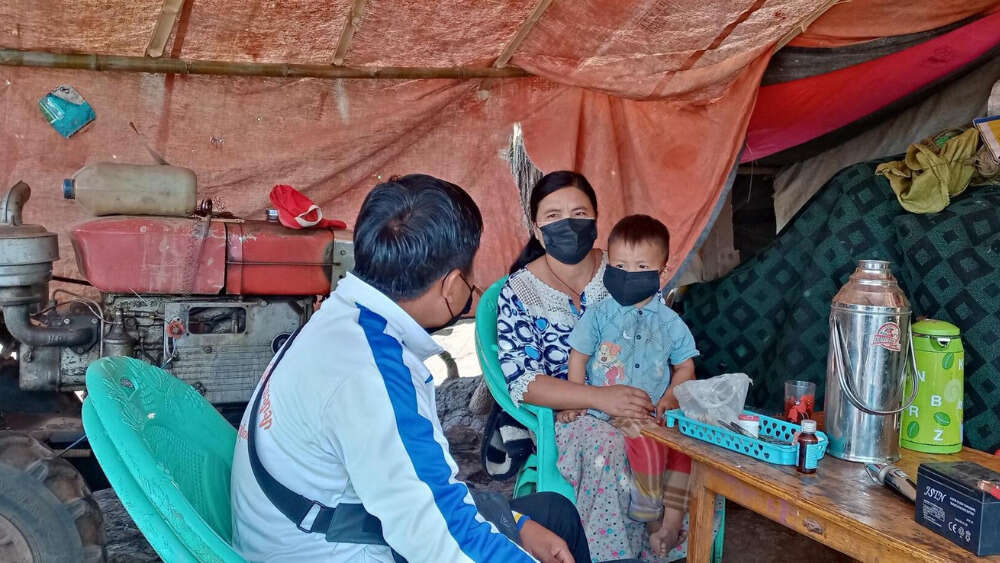 Kyaw Kyaw* meets with a displaced family who have received relief items such as raincoat, warm jacket, water purifier (IDP communities are provided with water purifiers to get access to clean water) from World Vision to follow up about the family's situation.