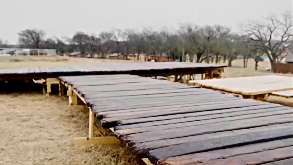 A wood artist has been distressing these planks that will become the wharves on the Sea of Galilee. Image: The Chosen's live stream Youtube.