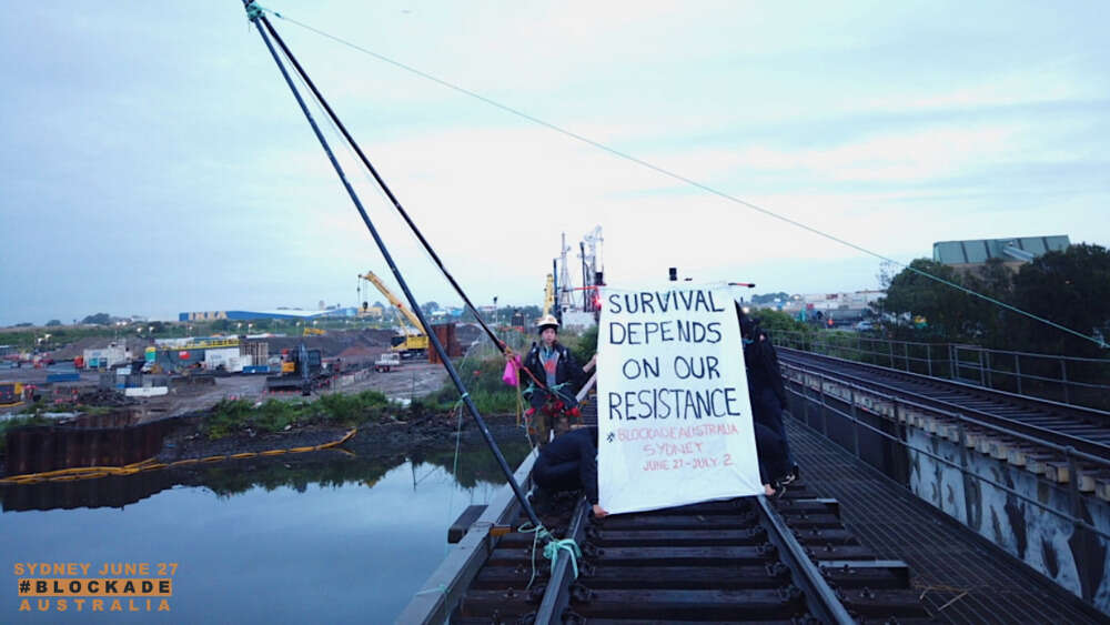 Climate Blockade protestor Emma (25) is suspended from a bipod structure, blocking freight trains entering and exiting the Port of Botany.