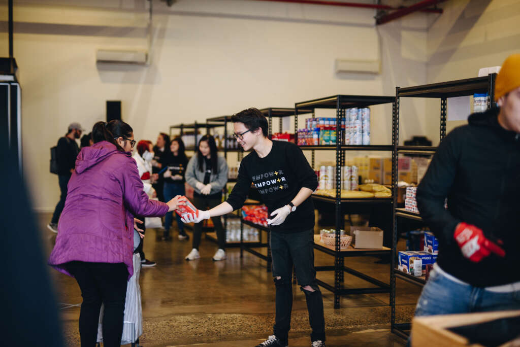 A volunteer assists at a visitor at Planetshakers a food relief centre