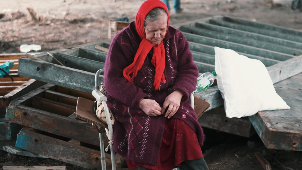 A Ukrainian woman sits among the rubble