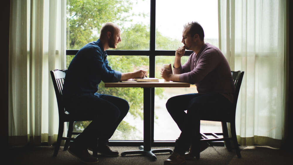 Two men reading Bible