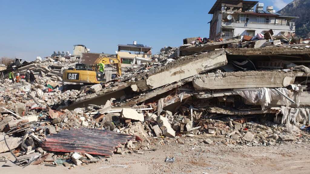 Machinery operators attempt to clear some of the rubble