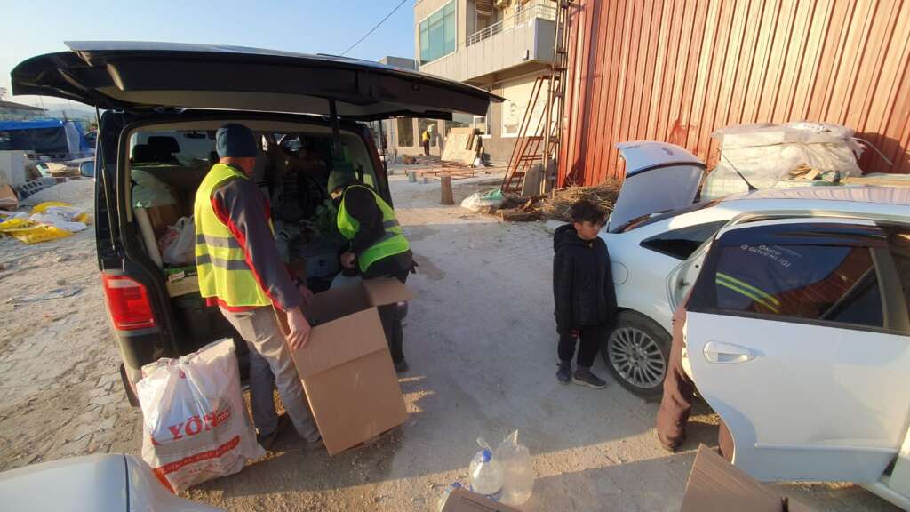 A couple of men and their sons collect supplies