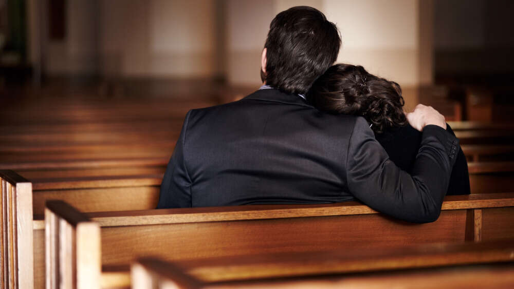 Man and wife mourning in church