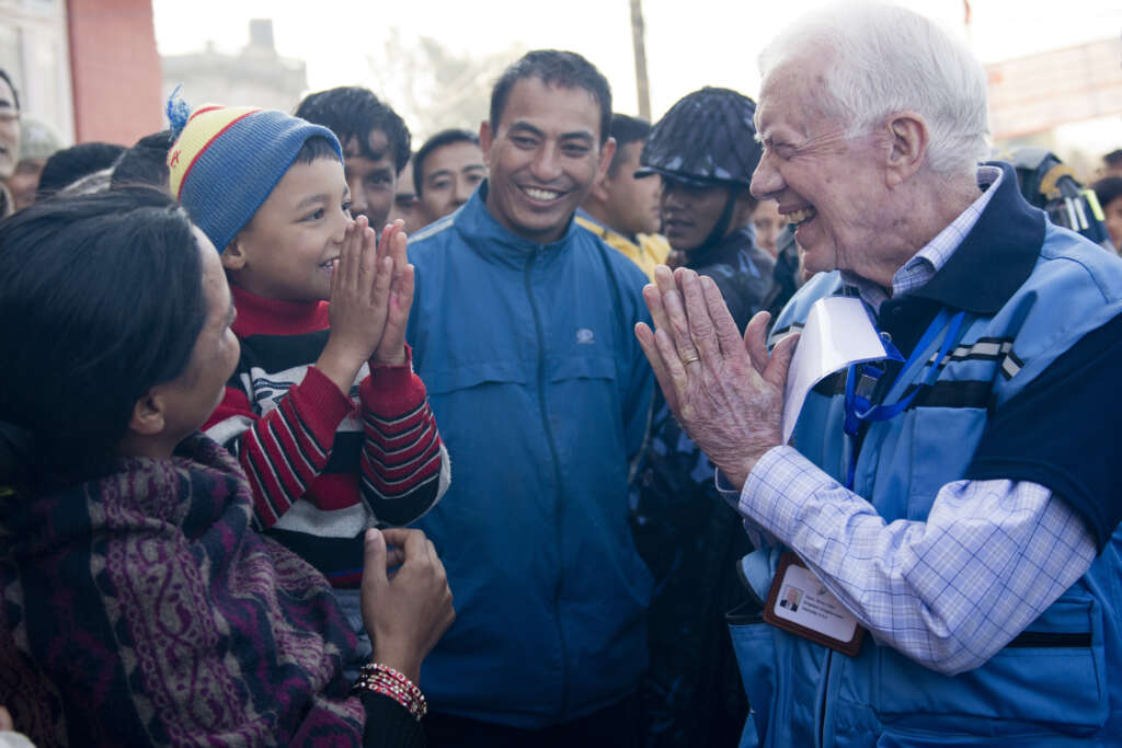 Former U.S. President Jimmy Carter greets a Nepalese boy in Kathmandu in 2013.