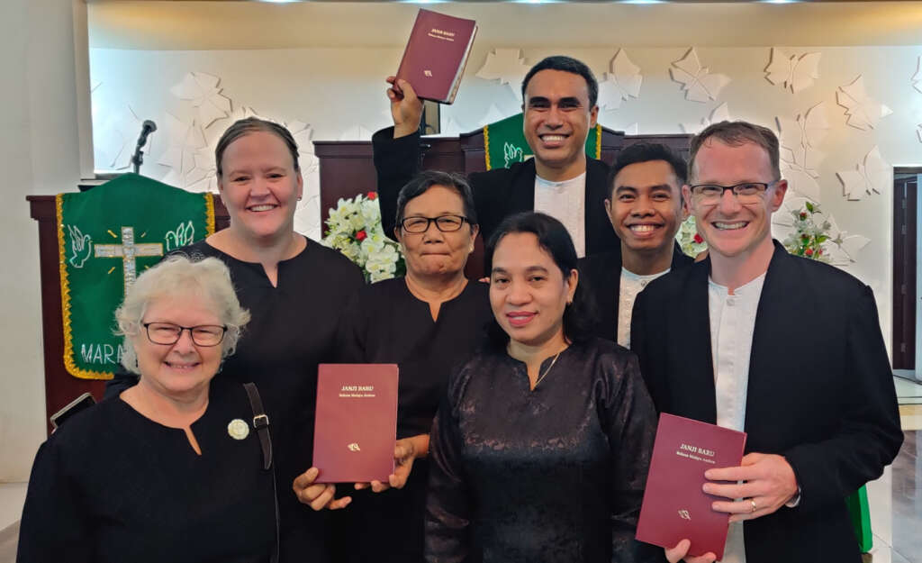 Translation team holding New Testament Ambonese Bibles