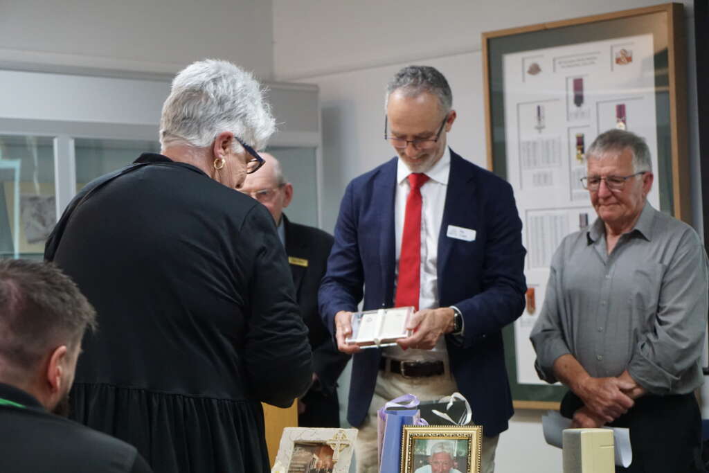 Nic Capp receives the New Testament of Philip J. Davies on behalf of the Bible Society of Australia