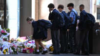 Students place flowers at a temporary memorial for Lilie James