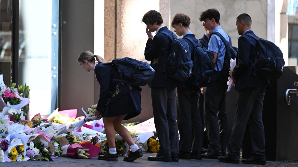 Students place flowers at a temporary memorial for Lilie James