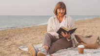 Woman reading a book on beach
